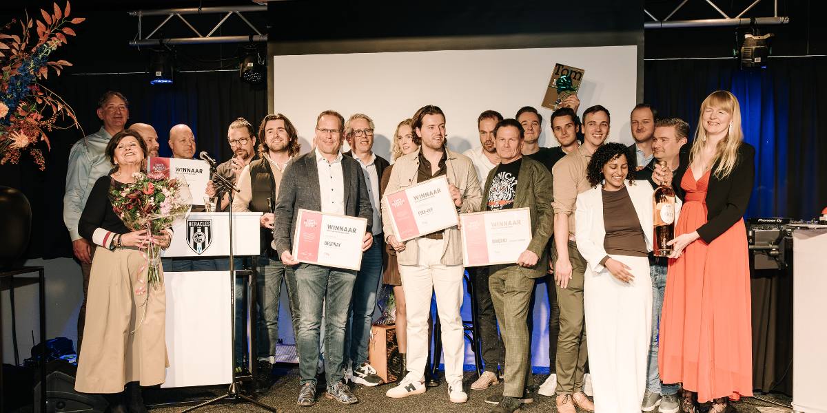 Winnaars van de Twentse Zakenverkiezing op het podium van TOM's Business Event